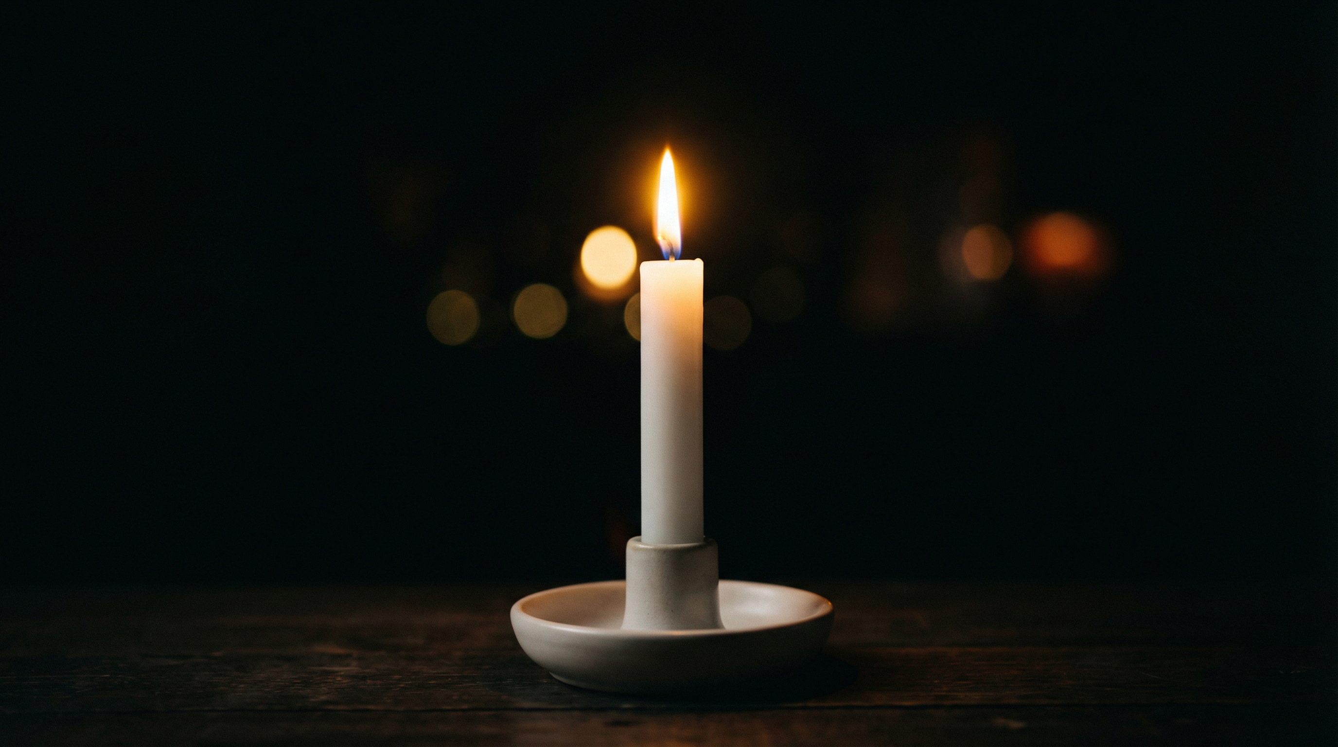 A single candle glowing in the dark